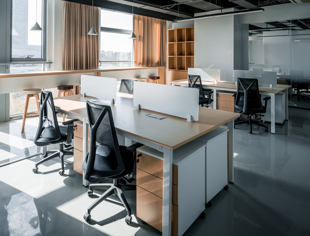 an office with a desk and chairs and a window